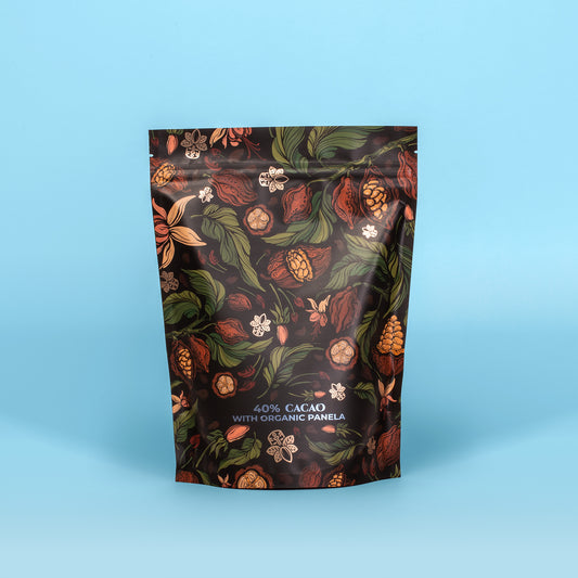 A sealed pouch packaging of Cocoda 40% Cacao with Organic Panela hot chocolate mix, featuring an illustration of cocoa pods and flowers on a dark background.