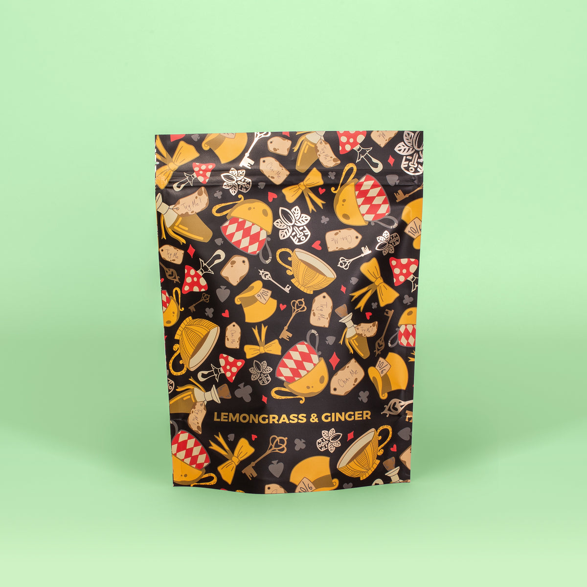 A packaged bag of Lemongrass & Ginger pyramid tea with a colorful pattern featuring lemons, ginger roots, and tea-related imagery.